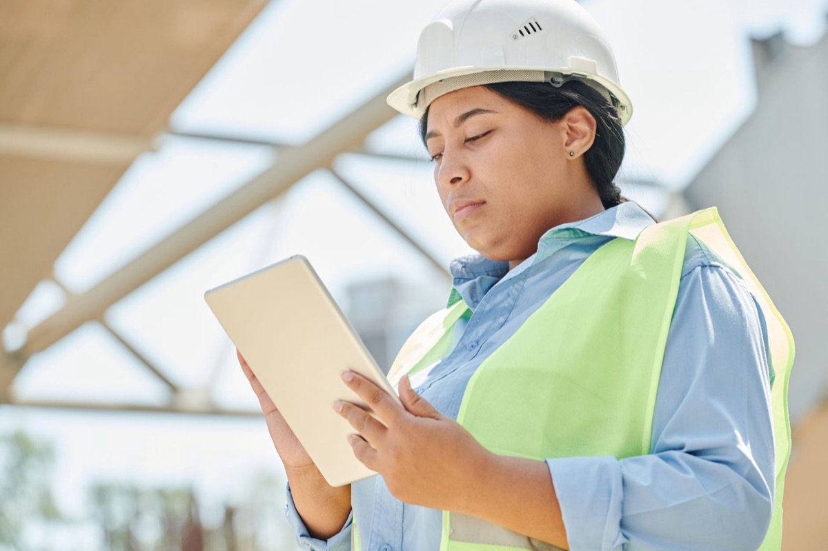 現場でタブレットを確認する建設技術者
