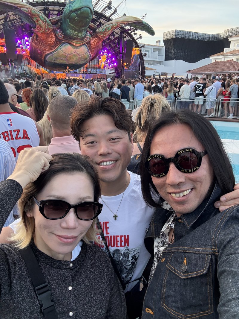 ウシュアイアのステージを背景にサングラスで写る旅の三人
