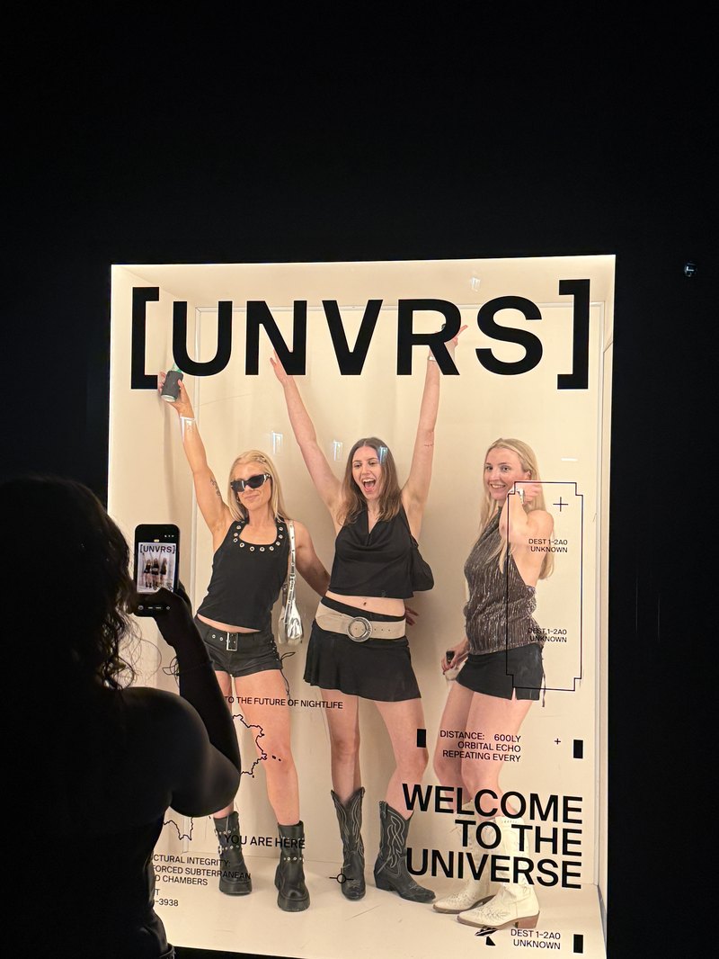 UNVRSの撮影スポット・[UNVRS]のロゴと『WELCOME TO THE UNIVERSE』の文字の前で写る人々
