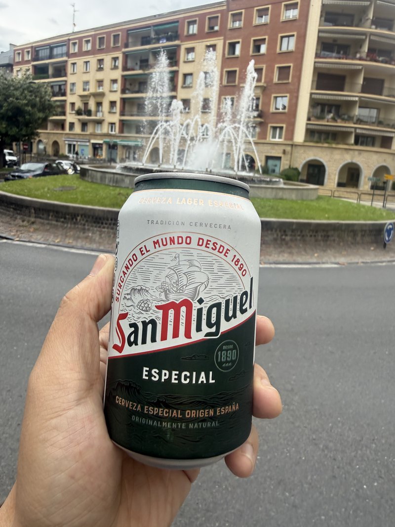 サン・ミゲルの缶ビールと噴水のある広場