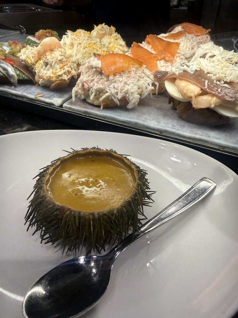 カウンターに並ぶウニの殻とカニサラダ・スモークサーモンのピンチョス