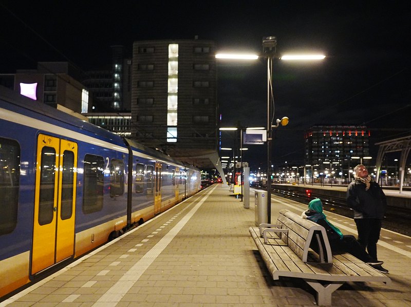 夜のアムステルダム中央駅のホームに停まる青と黄色のオランダ国鉄の列車