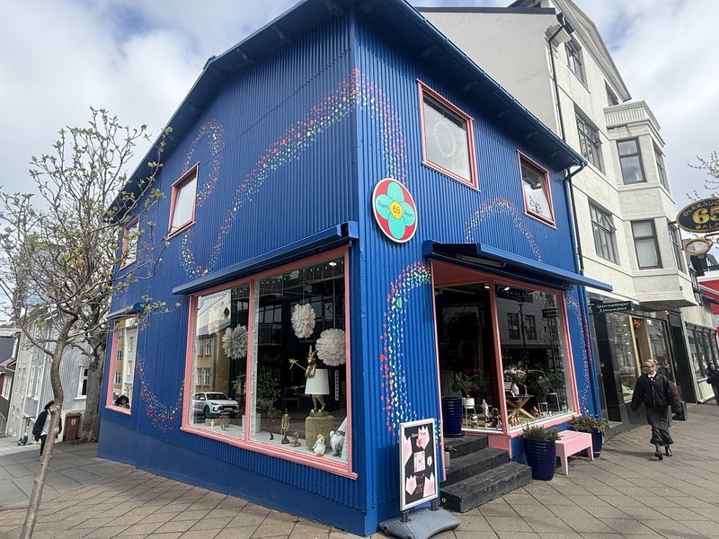 花の模様が描かれた鮮やかな青いトタン張りの雑貨店